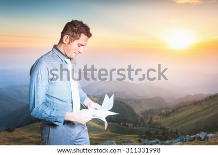 Handsome and successful man holding a document paper. Concept of professional career and future plans in business.