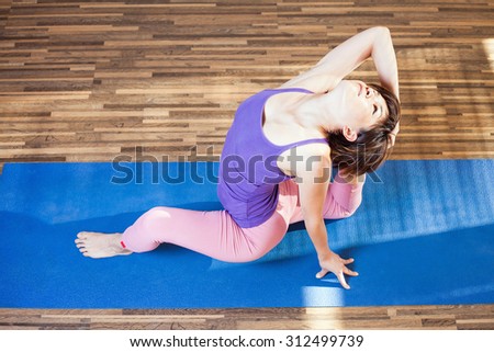Top view of inspired asian woman doing exercise of yoga indoor. Concept of exercise of yoga or fitness at home