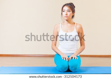 Inspired asian woman meditating before yoga exercise indoor at class of yoga. Concept of a healthy lifestyle, sport and the right attitude to life