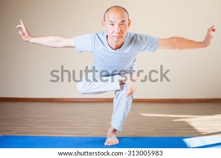 Inspired asian man doing exercise of yoga indoor at class of yoga or home. Concept of a healthy lifestyle, sport and the right attitude to life