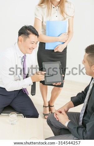 Image of concept of business meeting and conference at office. Asian businessman working or using tablet pc computer. There are a multiracial people of asian and caucasian
