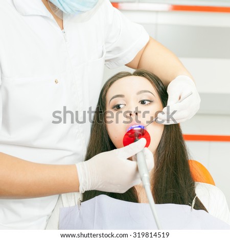 Dentist doctor treats teeth patient girl in dental office. Regular visits to the dentist will save you from tooth decay and you will always have healthy white teeth!