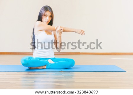 Asian woman warming up before yoga exercise indoor at home. Concept of healthy lifestyle with copy space for any text