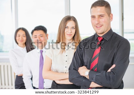 Successful young business man and business team of women and man at background. Image symbolizes a successful corporation or company, achieve success with intelligent and handsome men