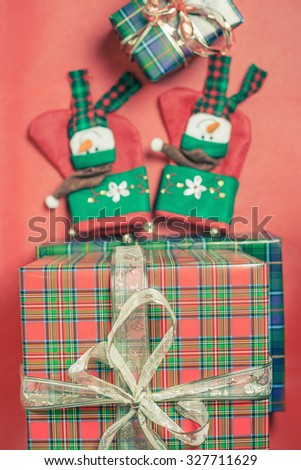 Christmas gift boxes with beautiful ribbon bow at red background with christmas socks