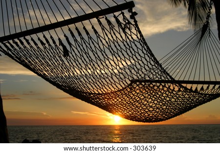 A hammock on the Big Island of Hawaii with the sunset in the background.