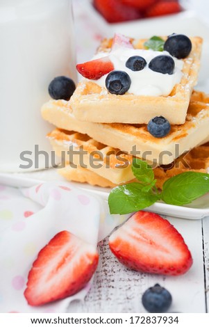 Delicious Belgian waffle with fresh berries and cream for breakfast