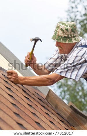 The worker repairs an apartment house roof
