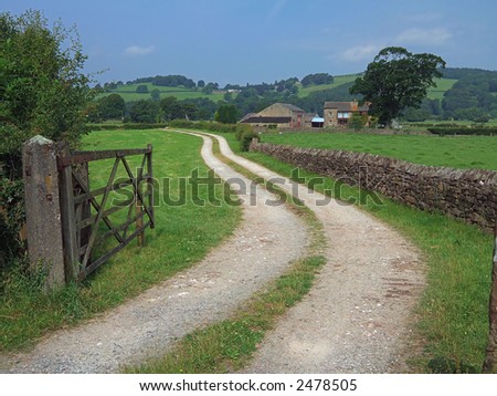 Winding farm track and open gate to farm near Lancaster, England