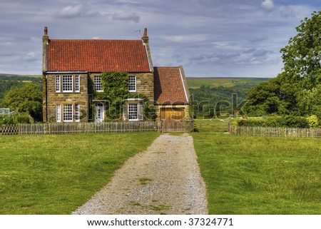 Long drive leading to detached house in countryside.