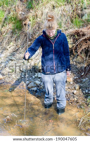 KALMAR, SWEDEN - APRIL 23, 2014: Person examining waterspeed in creek to establish water flow.