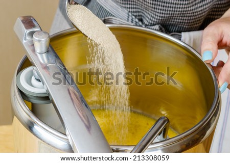 Female adding dry yeast into food processor when baking.