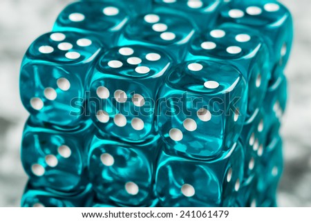 Stack of shiny blue plastic dices with white dots. Dices are transparent.