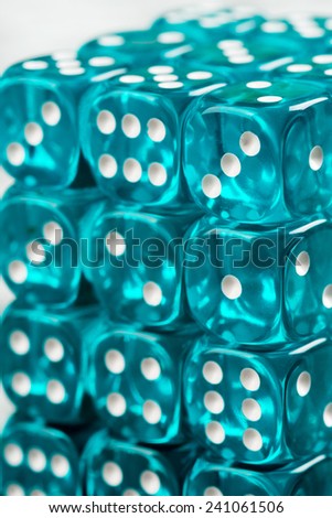 Stack of shiny blue plastic dices with white dots. Dices are transparent.