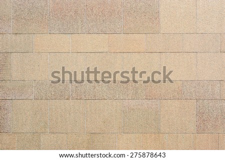 Fine stone wall in grayish beige color. Stone blocks of different size are used to create the pattern.