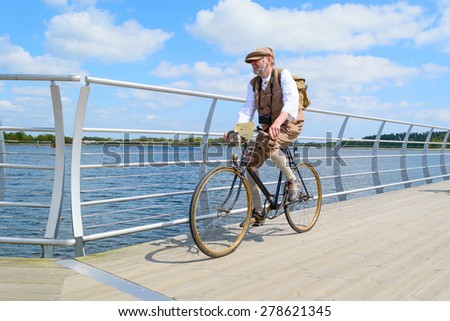 SOLVESBORG, SWEDEN - MAY 16, 2015: International Veteran Cycle Association (IVCA) 35th rally. Costume ride through public streets in town. Senior man on bike.