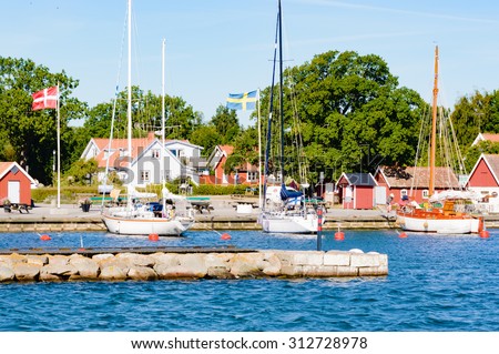 KRISTIANOPEL, SWEDEN - AUGUST 13, 2015: The marina as seen from the sea with small huts or cabins on land and some boats in the water. Tourism is booming in Sweden.