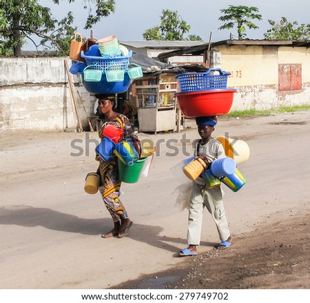 Brazzaville, Republic of Congo - May 1st, 2012: An African woman and child in Brazzaville the capital of the Republic of Congo carrying plastic water buckets on their heads.