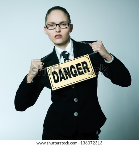 studio shot portrait of one caucasian young dangerous business woman woman  wearing a danger sign