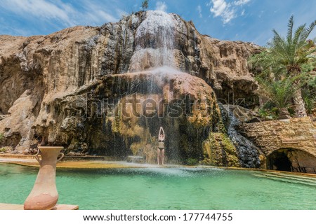 one woman bathing at ma\'in hot springs waterfall in jordan middle east