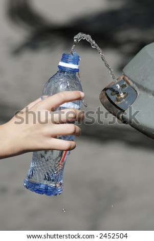 hand filling a bottle of water to a founatin