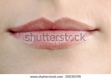 studio shot close up detail of the face of a beautiful young women with perfect lips mouth and teeth smilin