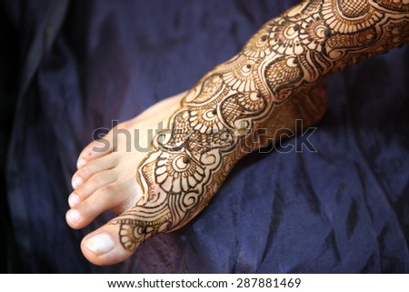 A Indian bride\'s feet with beautiful traditional design of mehendi.