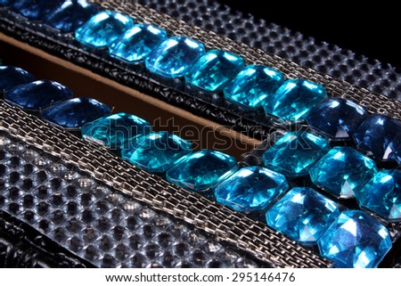 A beautiful design of blue beads and silver sequins on an old box.