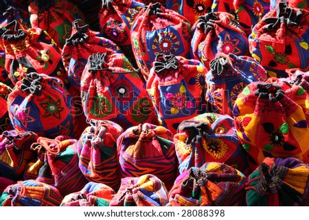 A background of bright colorful ethnic bags traditionally made in India, for sale in a shop in a flea market.
