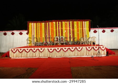 A view of an Indian wedding stage with traditional floral decoration.
