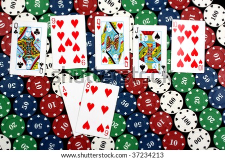 A poker hand called flush consisting of 5 cards of the same deck (hearts in this picture), on colorful gambling chips.