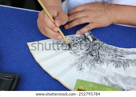 BANGKOK, THAILNAD - FEBRUARY 14: An unidentified Chinese artist painting in art souvenir at Central World Plaza during the Chinese New Year celebrations on February 14, 2015 in Bangkok, Thailand