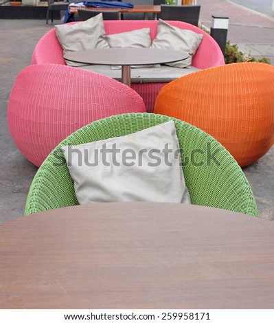 Wooden table and Cushions on a rattan sofa with artificial leather seat
