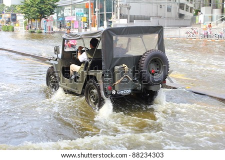 BANGKOK THAILAND - NOVEMBER 5 : Unidentified driver in car escape rising flood waters at ladprao Road, in Bangkok, Thailand on Nov. 5, 2011.