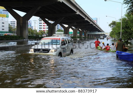 BANGKOK THAILAND - NOVEMBER 8 : Unidentified people driver in car to escape rising flood waters at ladprao Road, in Bangkok, Thailand on Nov. 8, 2011.