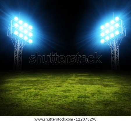 Green soccer field, bright spotlights, illuminated stadium
