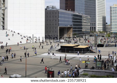 PARIS, FRANCE - SEPTEMBER, 2, 2014. Corporate office buildings in the financial center La Defense, Paris. There are a lot of people walking on the square before the Grande Arche.
