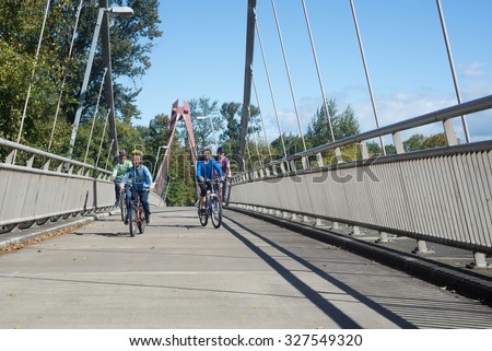 A young family rides across the Willamette River on the DeFazio Bike Bridge in Eugene Oregon