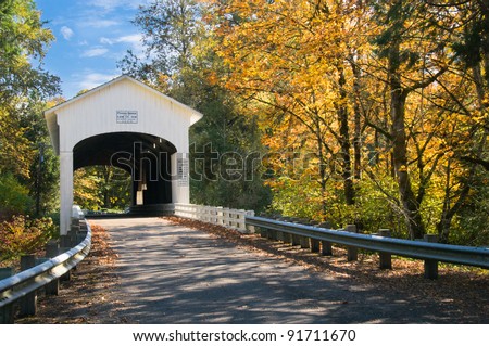 The pengra covered bridge with dappled sun shining through fall leaves; one of many in Lane County, Oregon near Eugene.