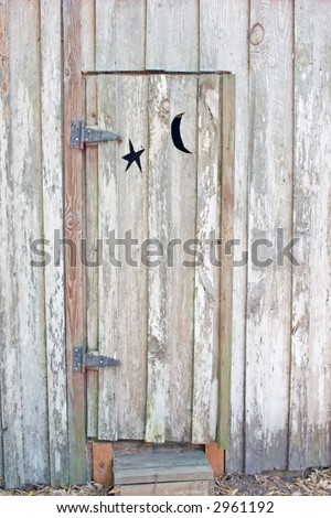 door of vintage outhouse with moon and star cutout