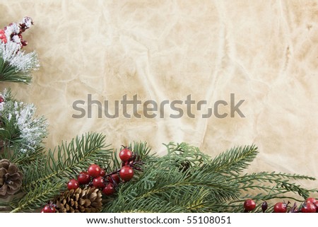 Christmas corner frame with fir branch, icy foliage, holly berries on antique paper with copyspace