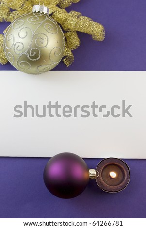 blank Christmas card with gold scroll ornament, purple bauble, tea light candle and copyspace