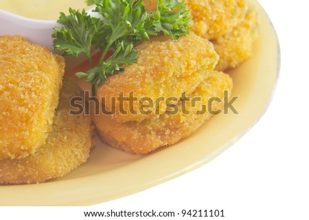 closeup of breaded chicken nuggets with honey mustard sauce