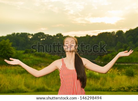 Happy and healthy woman meditating in one with nature at dusk