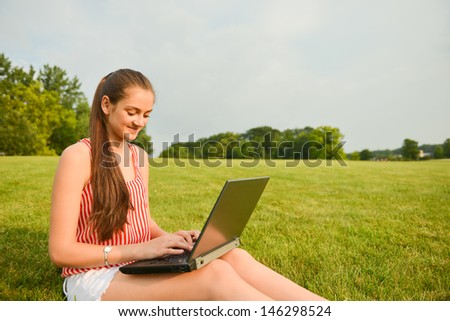 Woman working on laptop outside for work/life themes
