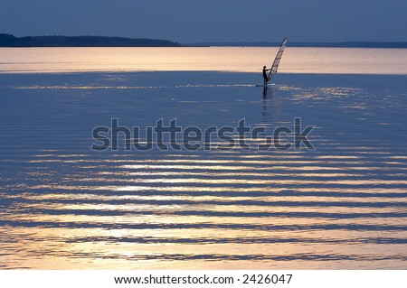 windsurfer in patches of light of a sunlight