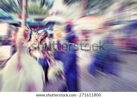 Abstract background. Blurred crowd, bride and groom on the Boulevard Montmartreon  in Paris - radial zoom blur effect defocusing filter applied, with vintage instagram look.