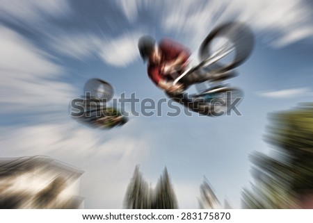 Abstract background . Two BMX bikers high up in the air. Some motion blur on both bikers.