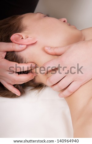 A woman getting a stress relieving pressure point massage on her neck by a health therapist
