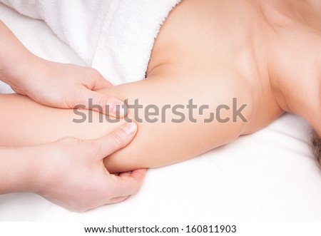 Therapist doing a pressure point massage of deltoid muscle on a woman\'s right shoulder